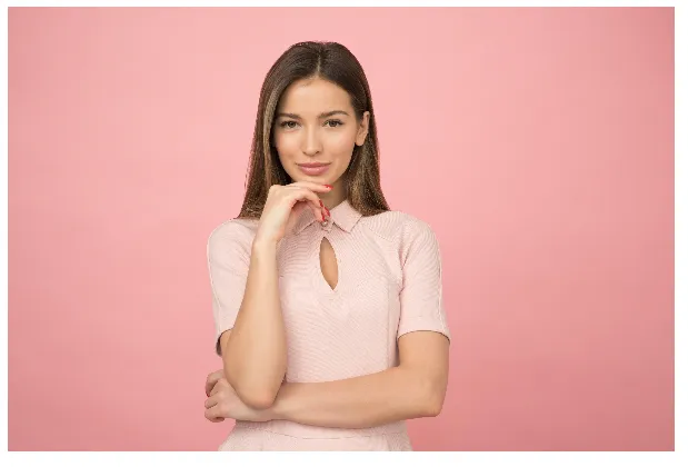 Woman in a pink dress resting her hand under her chin